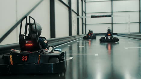 racing electric go karts in an indoor track with friends