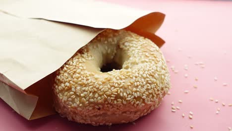 sesame bagel in a brown paper bag