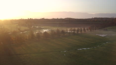 Vista-Aérea-Sobre-Campos-Paisajísticos-Con-Un-Impresionante-Amanecer