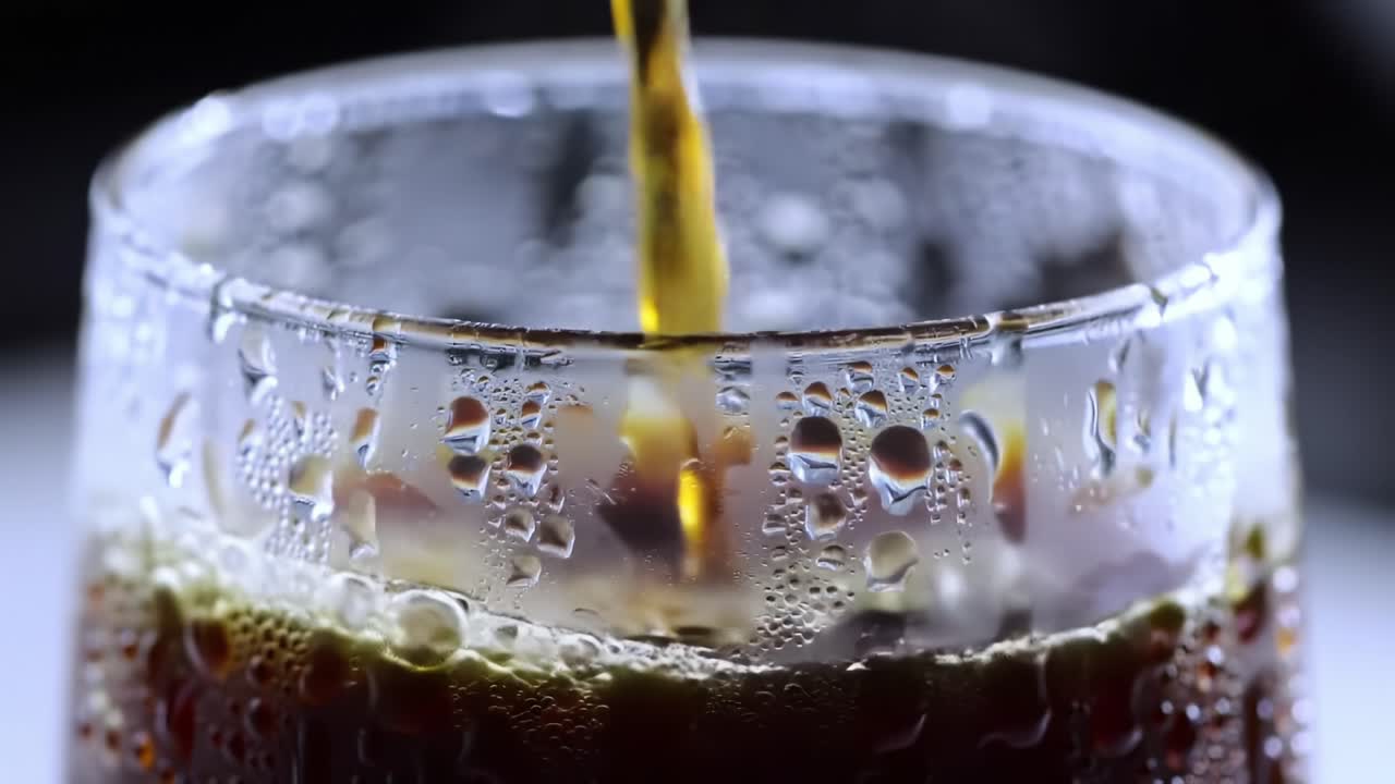 Captivating Close-Up of a Refreshing Beverage: Pouring a Golden Liquid into a Frosted Glass with Bubbles and Condensation, Highlighting Refreshing Sensation