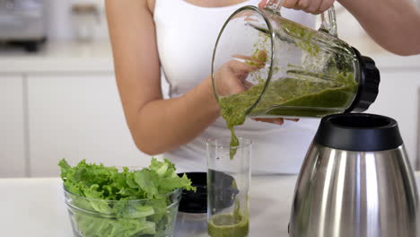 woman pouring smoothie in a glass