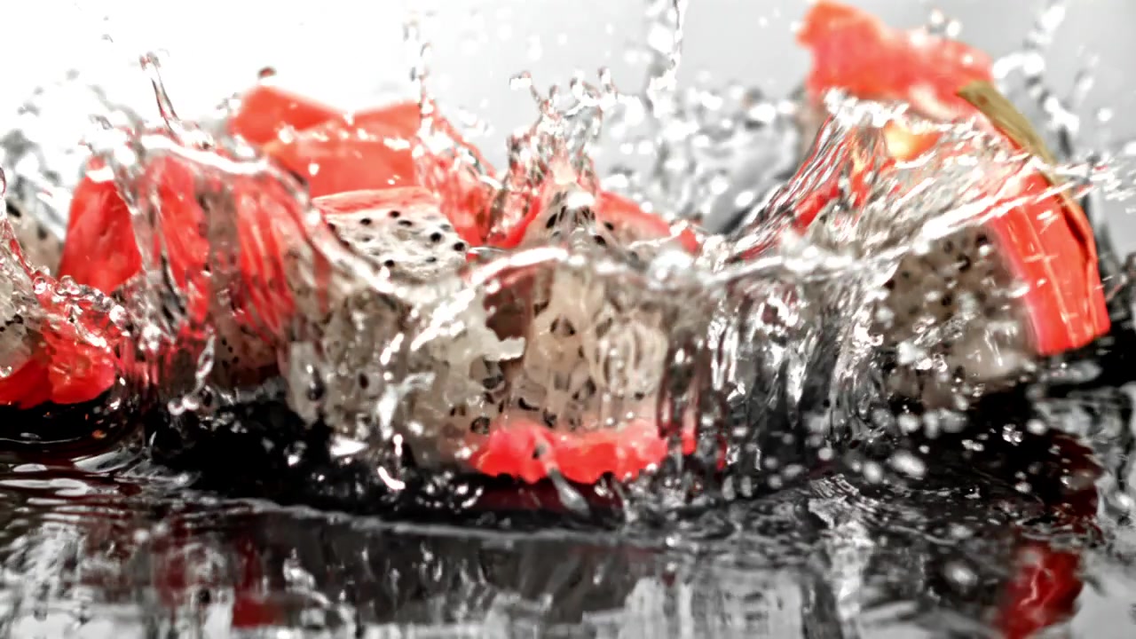 Fresh Dragon Fruit Pieces Splashing into Water in Slow Motion