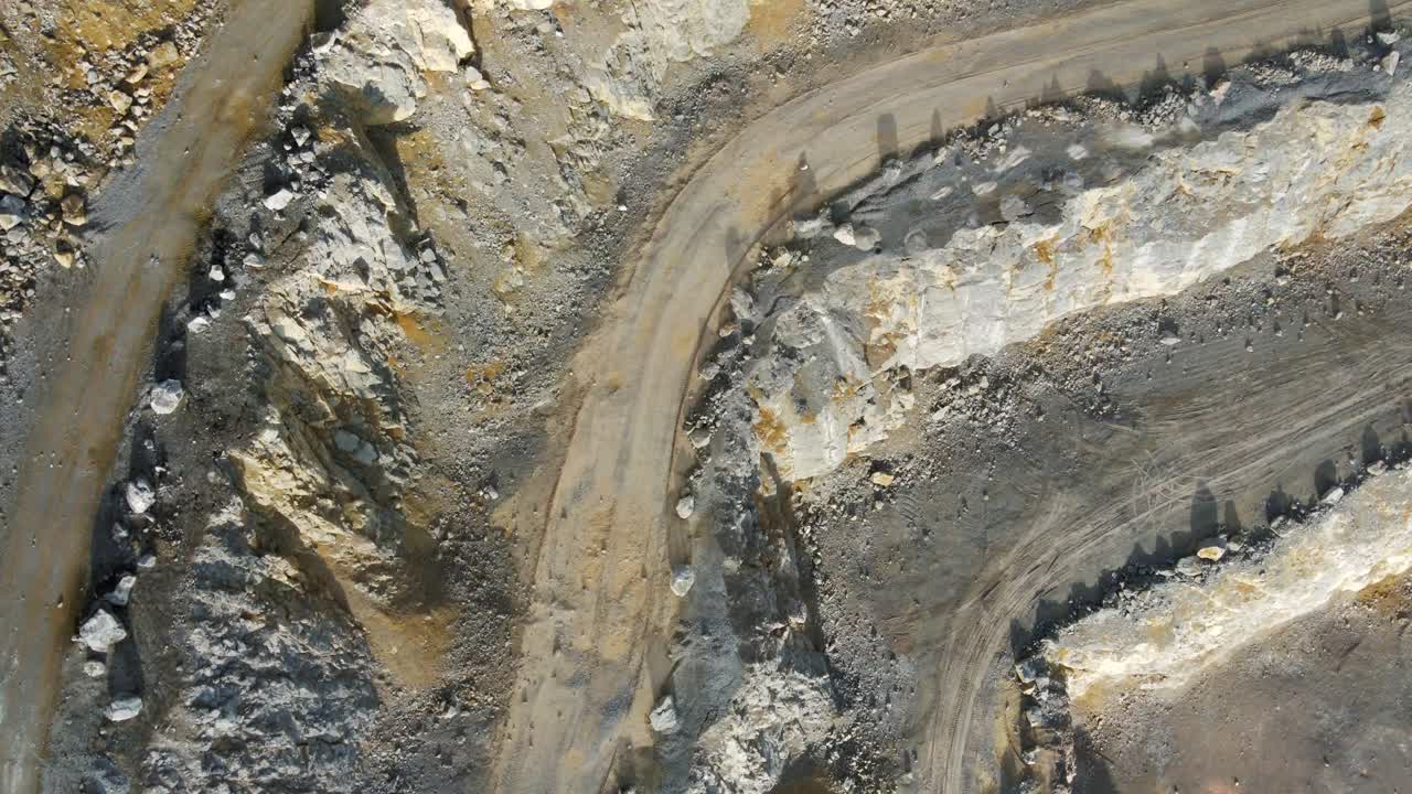 An aerial overhead view of a limestone quarry's haul road ramps