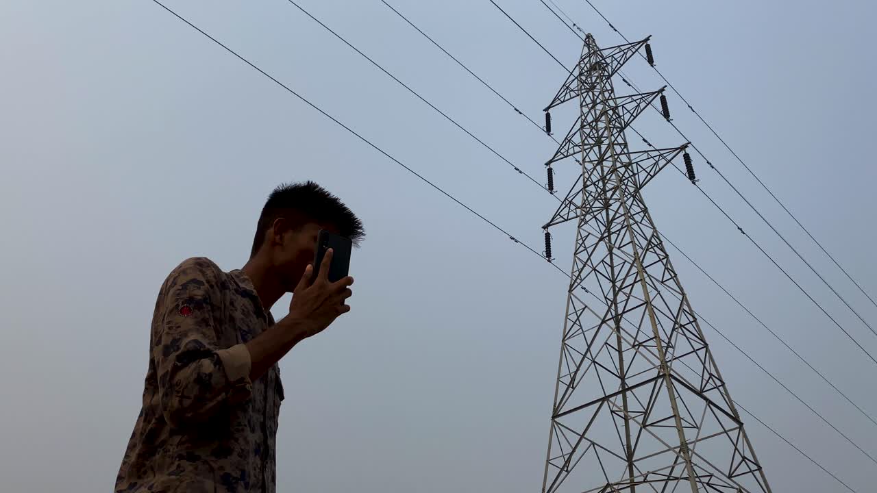 Rural village man making call near network tower for better signal in ...