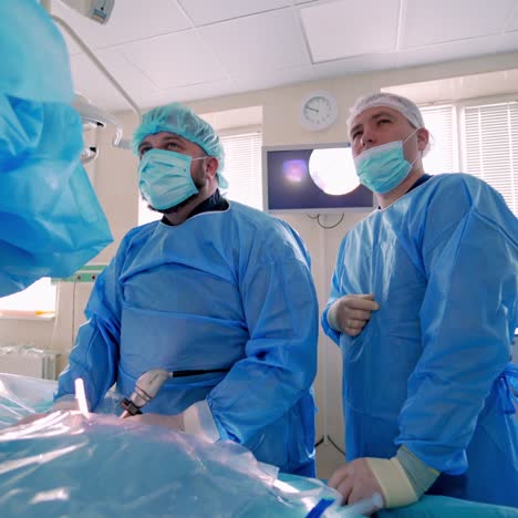 medical specialists in modern operating room. doctors perform a surgery and looking on the process on the monitor