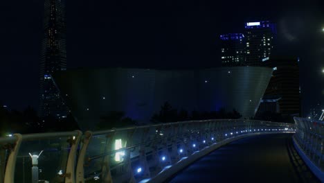 parque urbano de la ciudad nocturna con arquitectura y edificios con puente y luces al aire libre en la calle