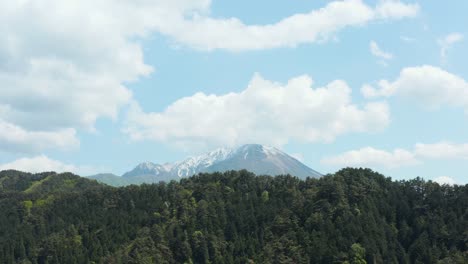 aerial reveal of mt daisen rising over forest, tottori japan