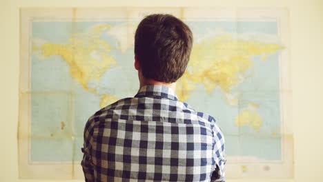 young tourist man looking at world map