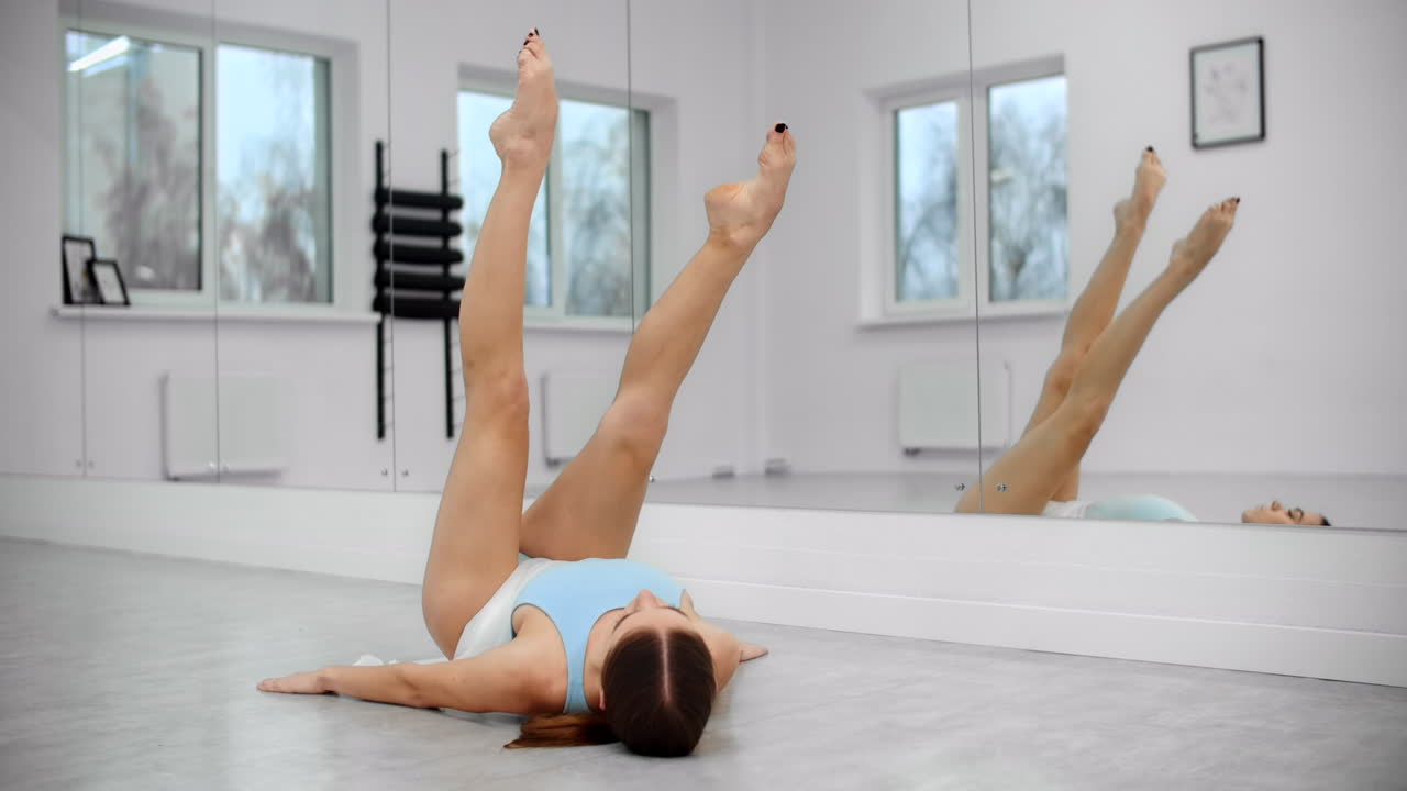 Woman Stretching Legs in a Dance Studio