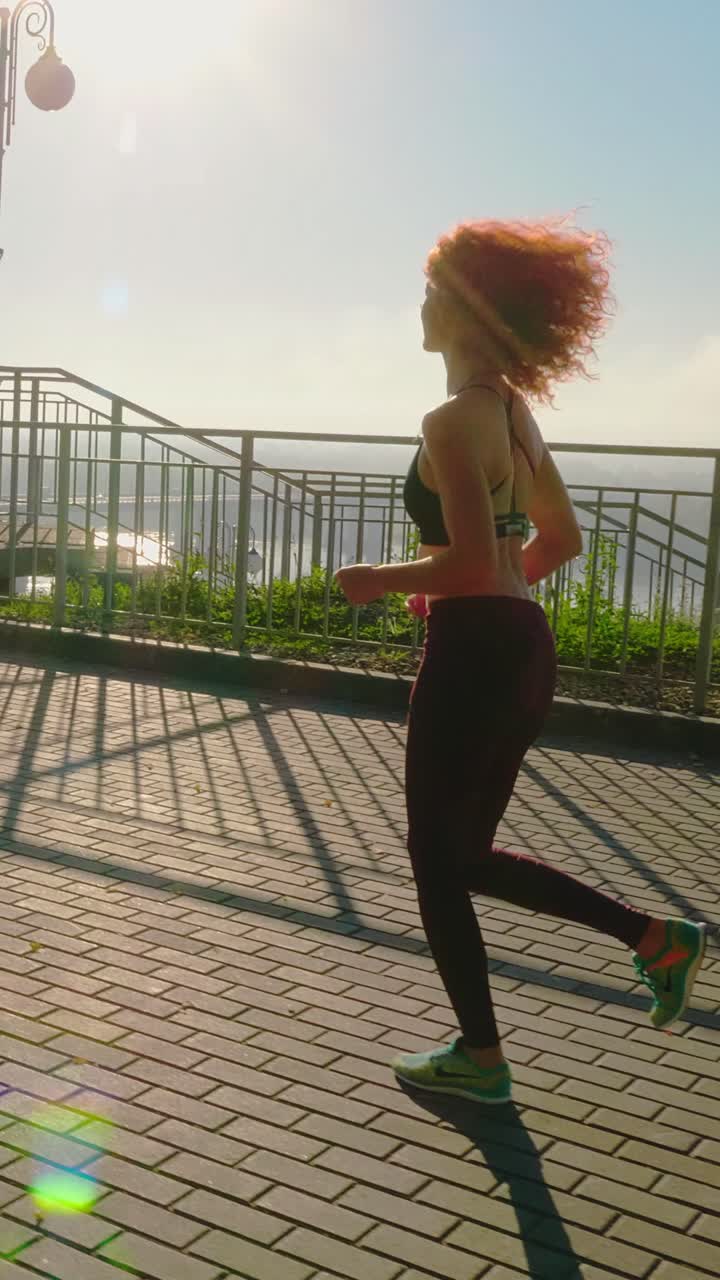 Athletic woman jogging along a scenic waterfront pathway during a sunny day with vibrant atmosphere