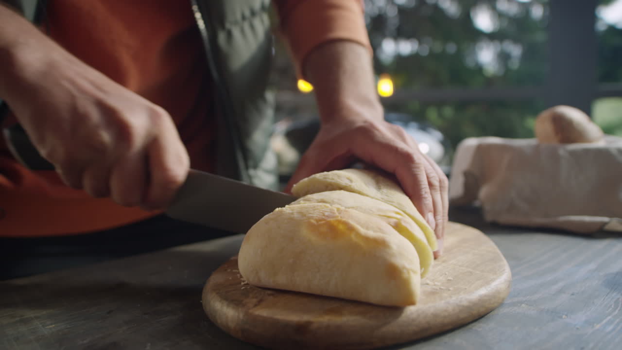 Cutting Ciabatta Bread on Outdoor Terrace