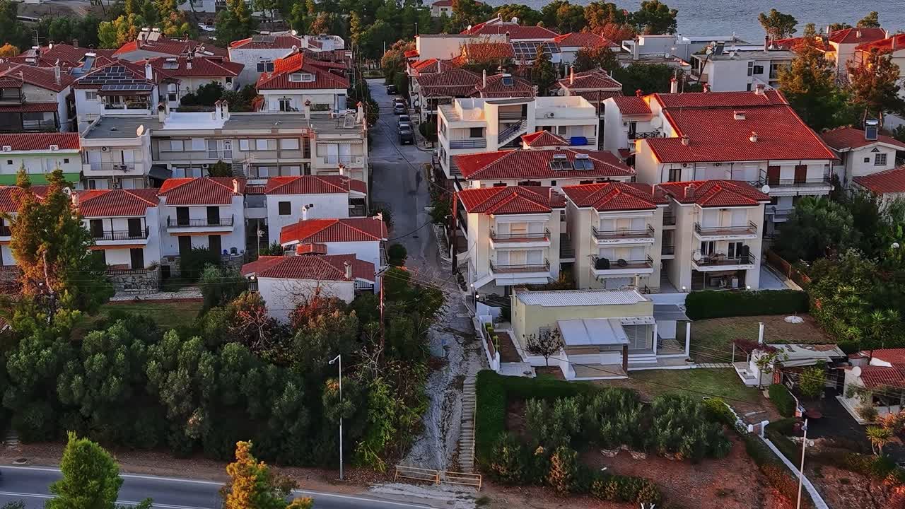 Huse og gader i et kystområde i Grækenland ved solnedgang