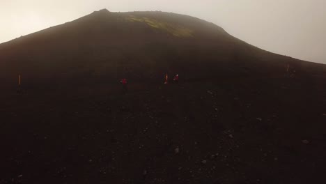 aerial landscape view of people hiking on a mountain trail, on a foggy day, fimmvörðuháls area, iceland