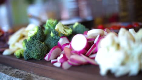 a slow panning shot over a platter of vegetables including broccoli, cauliflower, mushrooms, carrots, beats, radishes, etc..