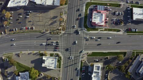 Vista-Aérea-Desde-Arriba-De-Un-Drone-De-Una-Concurrida-Intersección-De-Carreteras-En-Medio-De-Un-Centro-De-Negocios-Rodeado-De-Edificios-En-Un-Soleado-Día-De-Otoño-En-El-Condado-De-Salt-Lake,-Utah