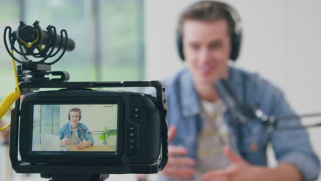 display on back of camera showing male vlogger live streaming to camera