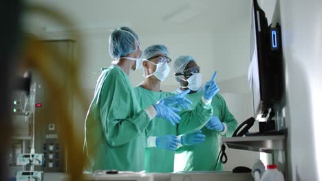 Seriöse,-Vielfältige-Chirurgen-Mit-Gesichtsmasken-Inspizieren-Röntgenaufnahmen-Im-Operationssaal-In-Zeitlupe