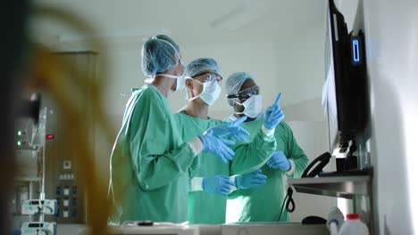 serious diverse surgeons with face masks inspecting xray in operating room in slow motion