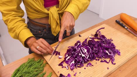 mujer cortando repollo rojo