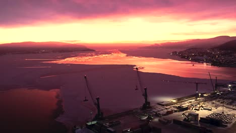 increíble amanecer rojo sangre sobre las grúas en el puerto de drammen durante el invierno