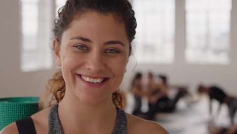 retrato hermosa mujer de yoga sonriendo con confianza mujer caucásica disfrutando de un estilo de vida saludable con gente practicando en el fondo del gimnasio