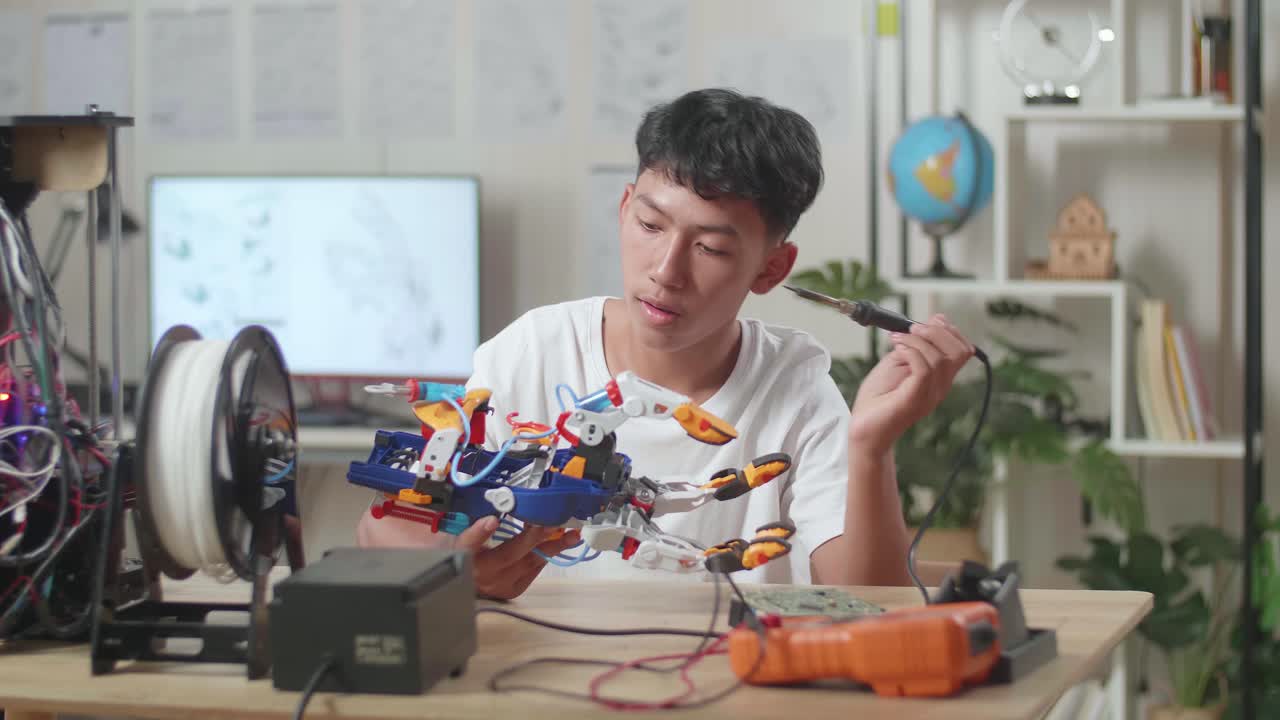 un niño asiático reparando una mano de cyborg en casa.