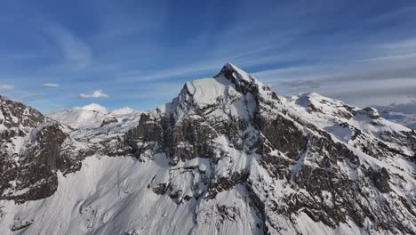 el pico de fronalpstock cubierto de nieve con acantilados escarpados y un cielo azul claro en glarus nord, suiza