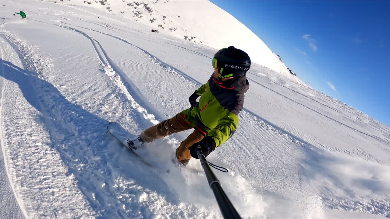 Selfie footage of a quick snow ride from the mountain slope. Snow flies to the camera.