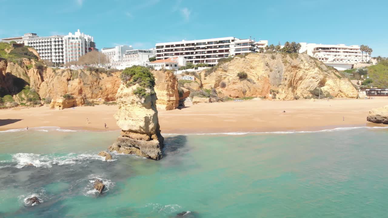 la idílica playa de doña ana rodeada por los acantilados de lagos y el mar turquesa del algarve, portugal - toma aérea de revelación de vuelo bajo hacia atrás