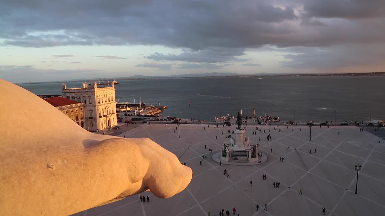 Wide view of people walking around in Praça do Comércio, Terreiro do Paço, right by the Tagus river, in the center of Lisbon, Portugal.