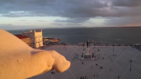 wide view of people walking around in praça do comércio, terreiro do paço, right by the tagus river, in the center of lisbon, portugal.