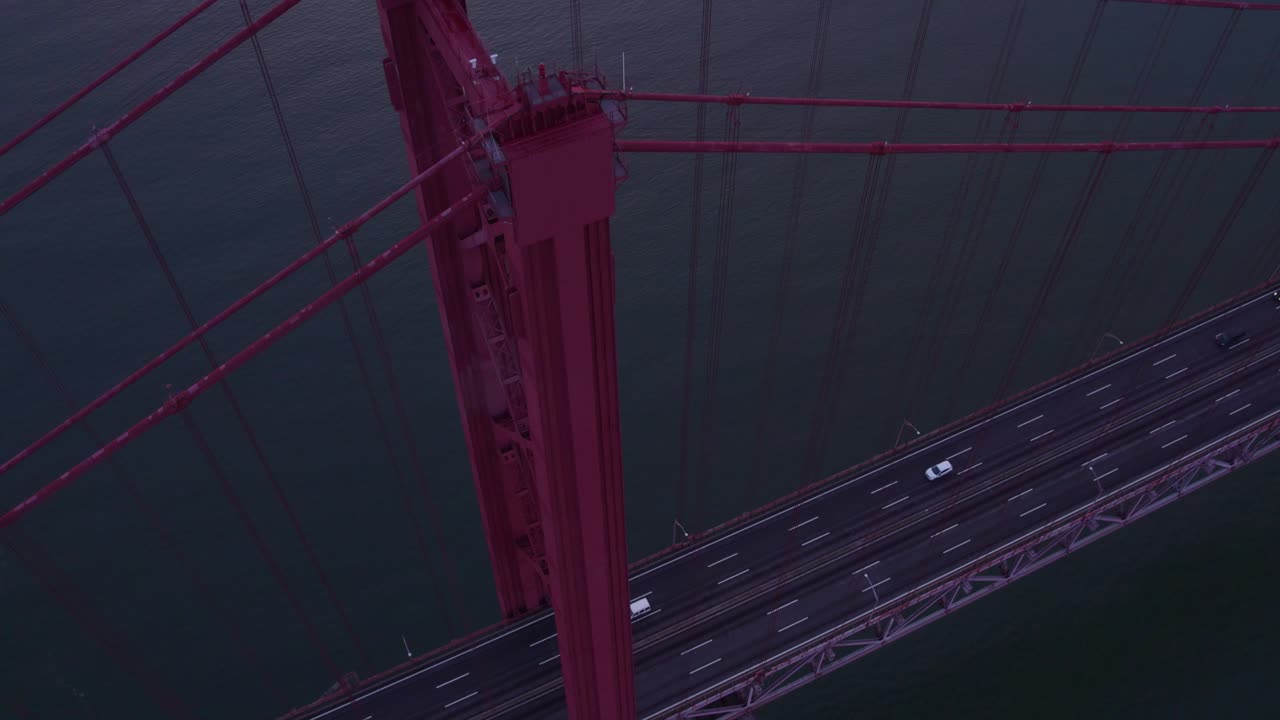 Vista aérea del Puente 25 de Abril con puente, amanecer, autopista, mostrando un vibrante paisaje histórico en Portugal