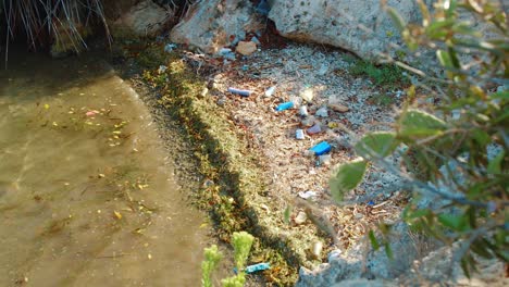 revelación aérea de botellas de plástico y basura lavada en la alcoba de la playa, día soleado