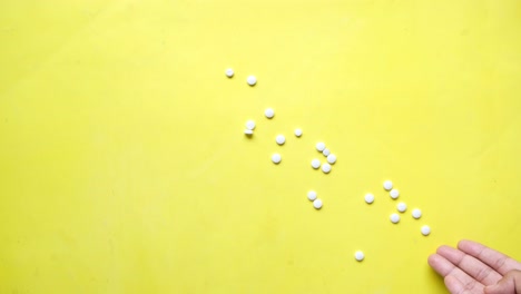 white pills on yellow background