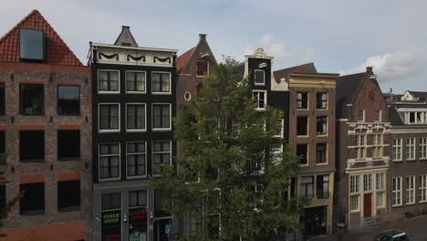 Top-to-down-aerial-shot-of-Amsterdam-city-with-buildings,-apartments-and-streets-during-a-clear-day-in-The-Netherlands