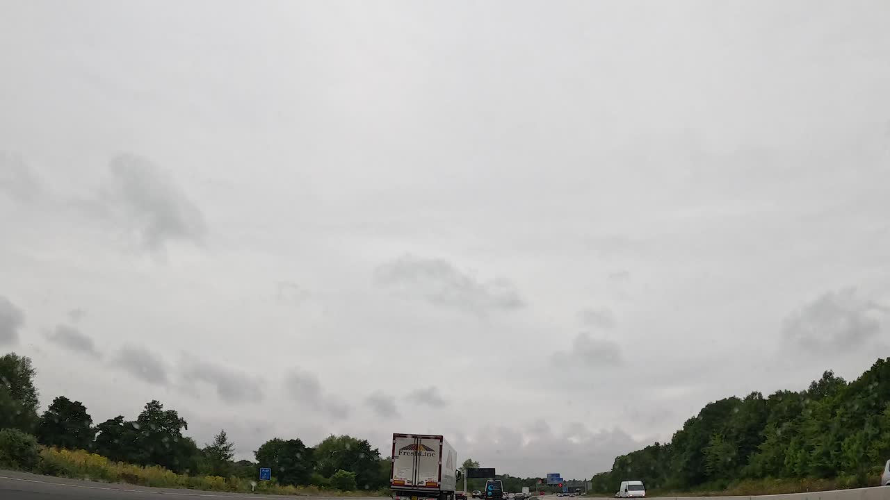 비가 오는 고속도로에서 자동차와 트럭을 운전합니다.