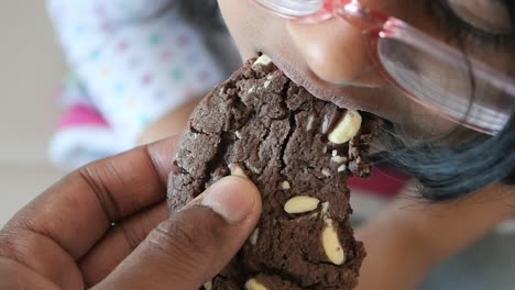 close up of a child eating a chocolate chip cookie