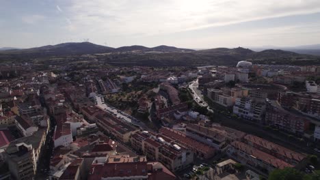 drone flyover historic plasencia townscape in spain, mountain range in distance