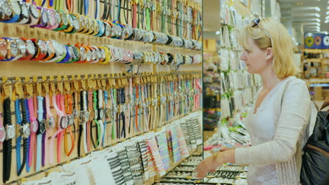 a young tourist chooses a watch in a gift shop on the beach