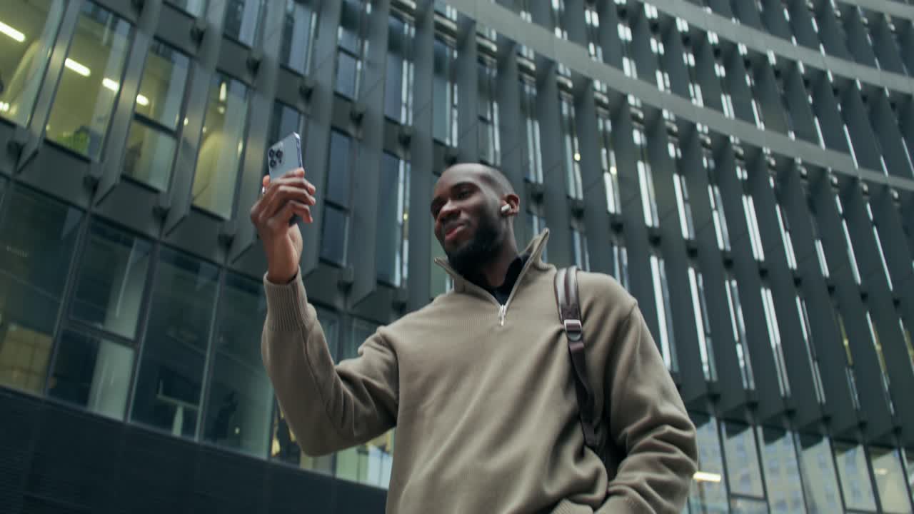 Man using smartphone in front of modern building