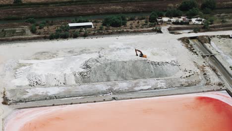 vista aérea de una excavadora en un montón de sal, infraestructura de una granja de sal marina, albania