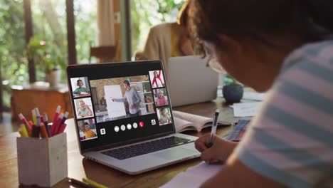estudiante que usa una computadora portátil para una lección en línea en casa, con un maestro y una clase diversos en la pantalla