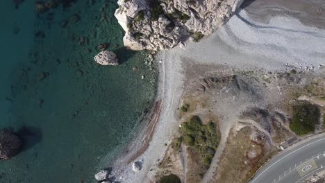 slow rising shot over an empty beach at aphrodite's rock in cyprus.