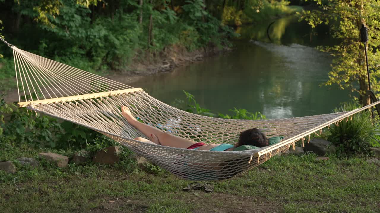 chica relajándose en una hamaca junto al río once point en thomasville missouri