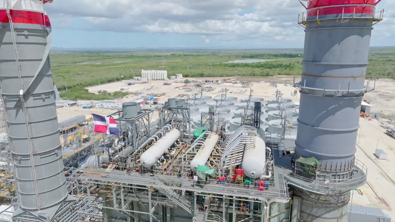 Flag Waving On Top Of Facility Of Combined-cycle Power Plant During Construction In Dominican Republic. - aerial shot