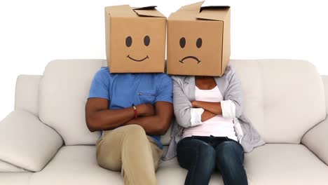 Team-sitting-on-sofa-with-emoticon-boxes-on-their-heads