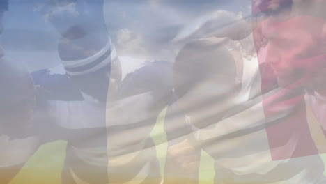 animation of waving france flag against team of diverse male rugby players discussing in a huddle