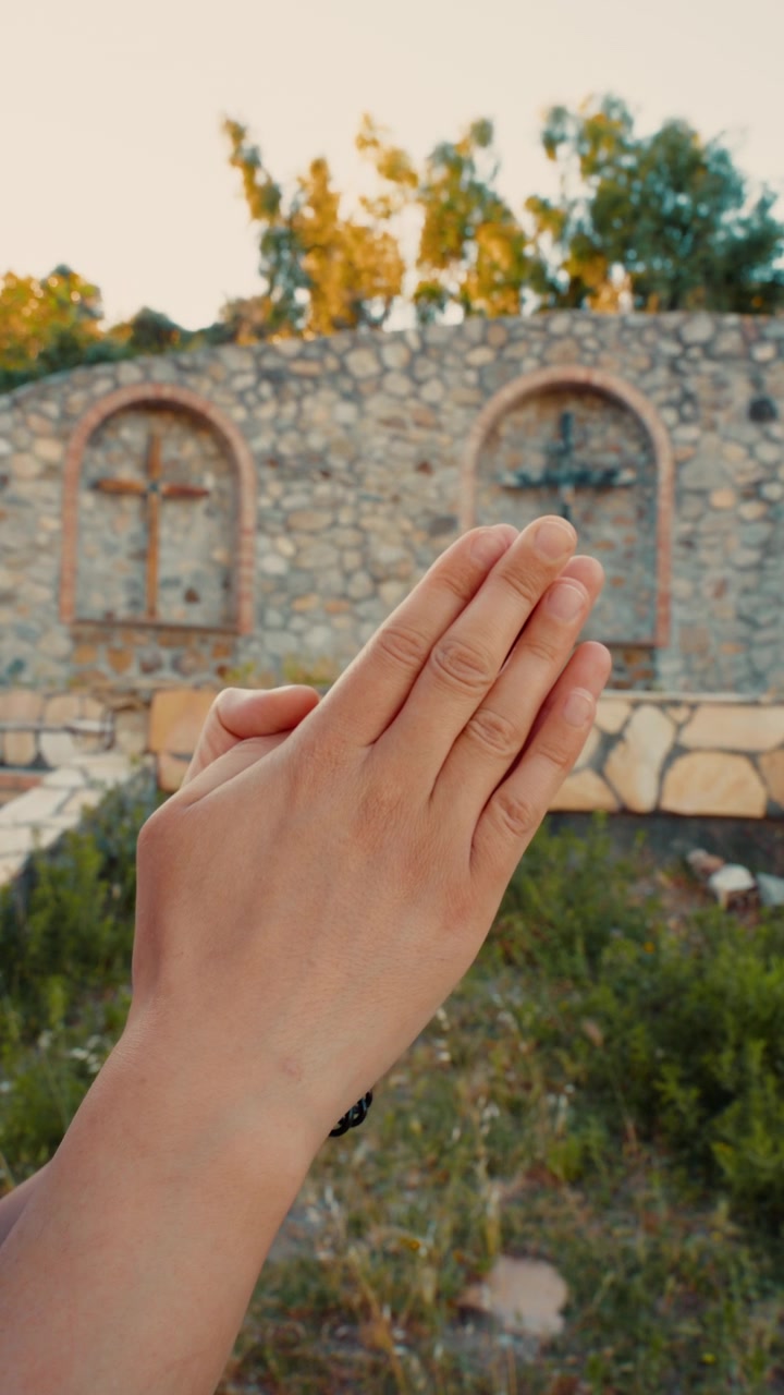 Una Donna con le Mani Giunte in Preghiera per la Fine delle Guerre nel Mondo Vicino a un Crocifisso Religioso