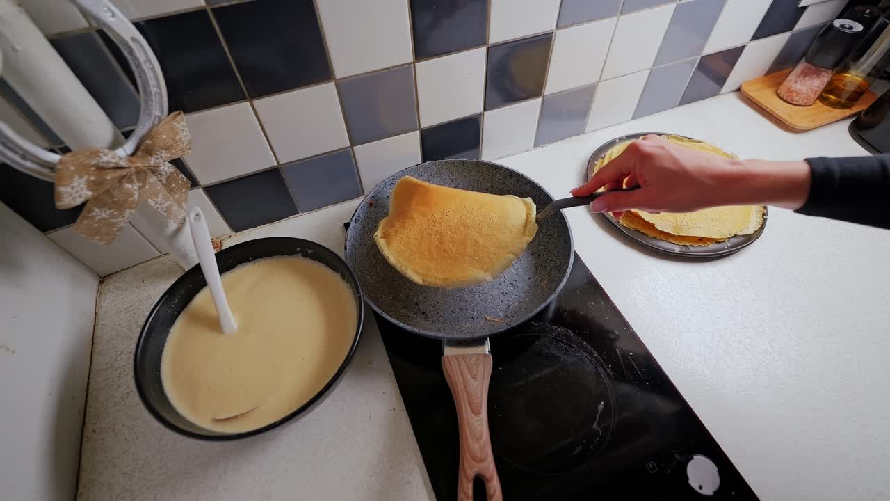 Golden pancake flips in slow motion from hot pan during home breakfast cooking