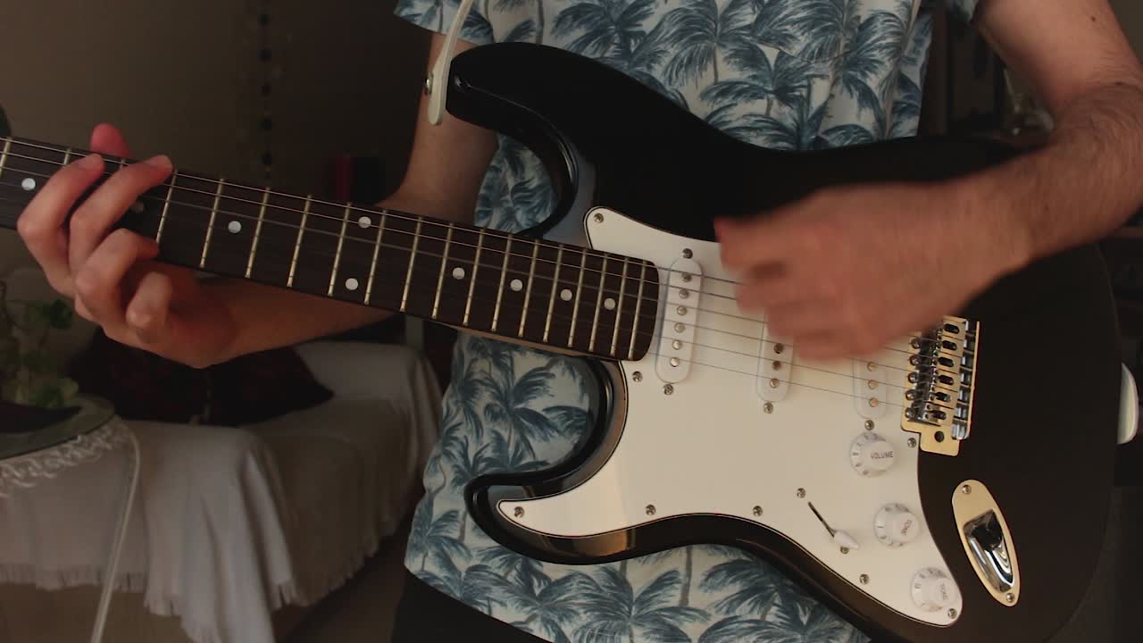 joven flaco tocando la guitarra eléctrica